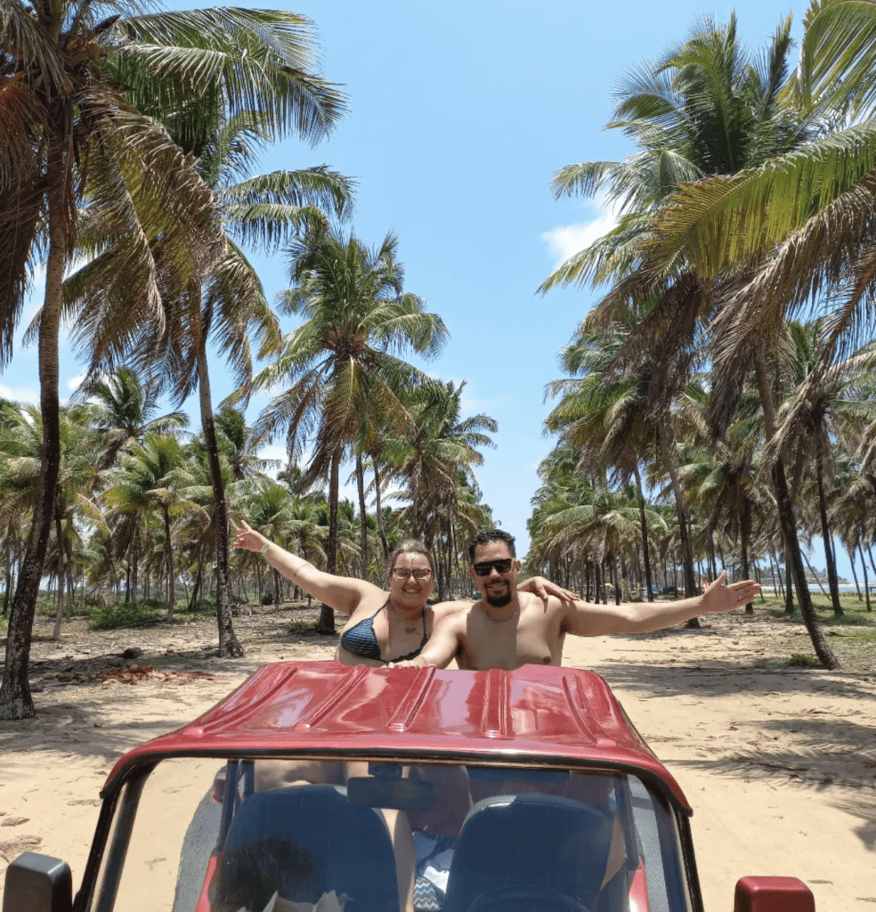 Casal feliz em buggy na praia em pernambuco.